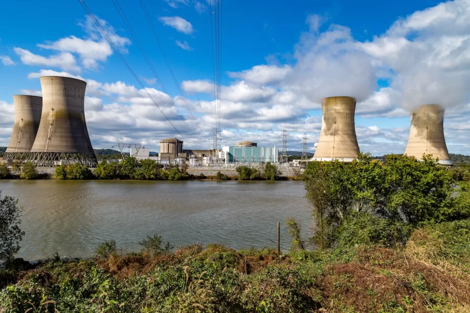 View of Three Mile Island nuclear power plant with four reactor towers on a sunny day.